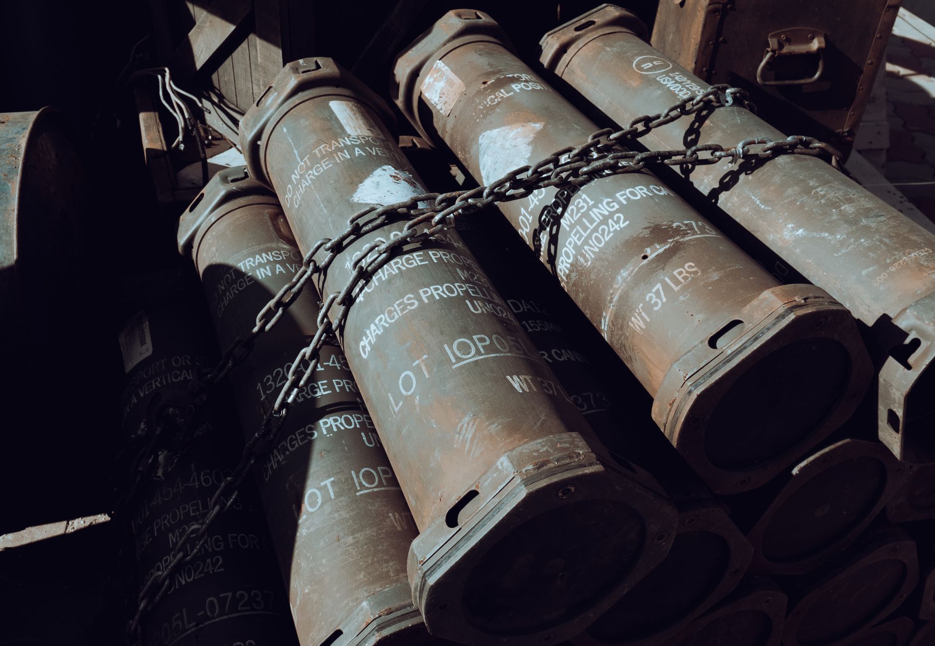 Close-up of chained military missile containers in a warehouse.