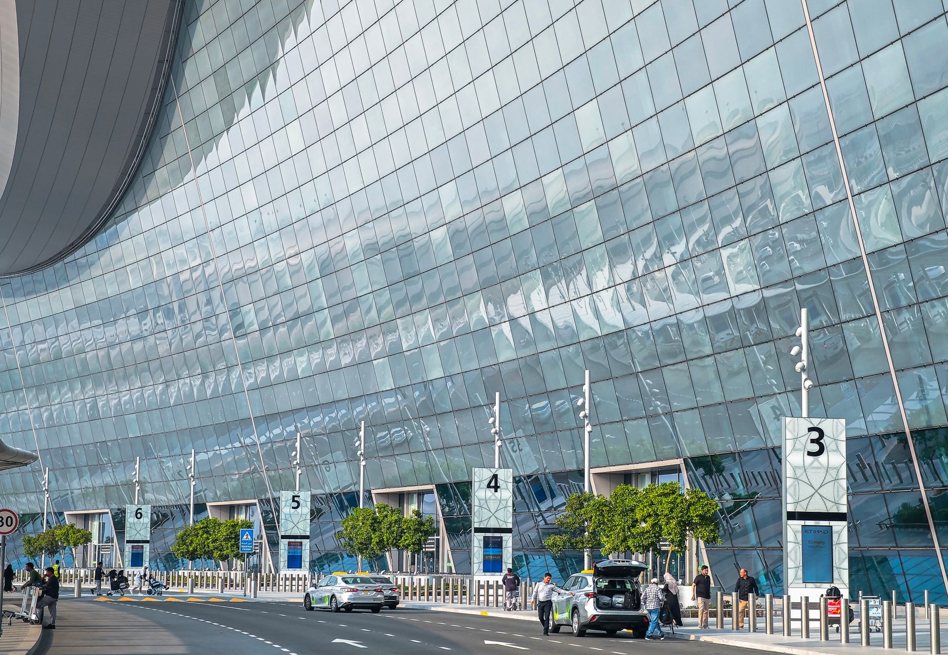 Stunning modern facade of an airport terminal in Abu Dhabi with reflective glass and contemporary design.