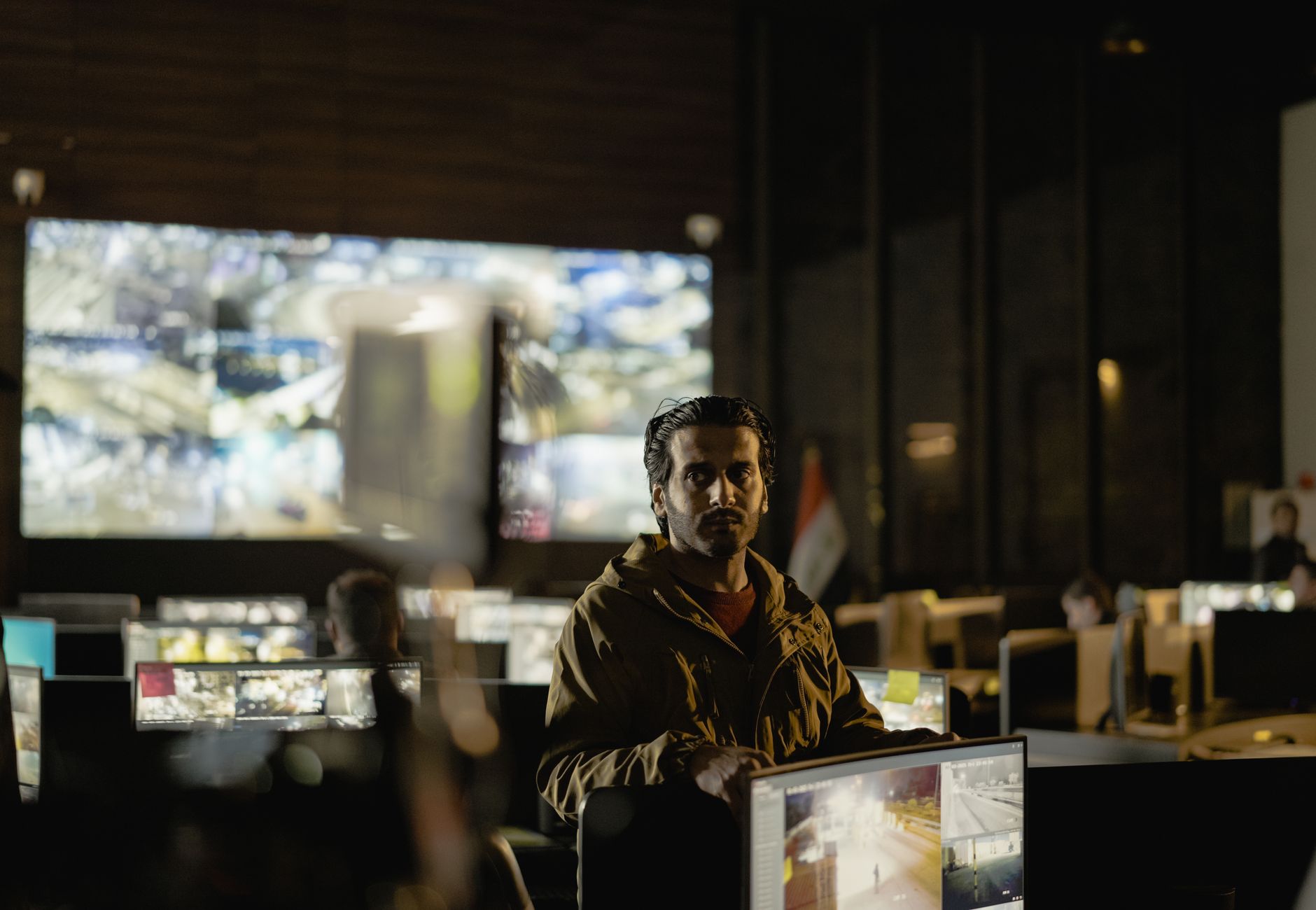 Modern security control room with a diverse team monitoring live surveillance feeds.
